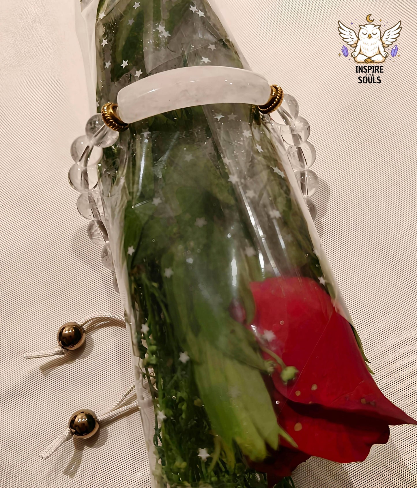 Bouquet of flowers with a clear quartz soulstone series by Inspirethesouls bracelet and decorative elements on a textured surface