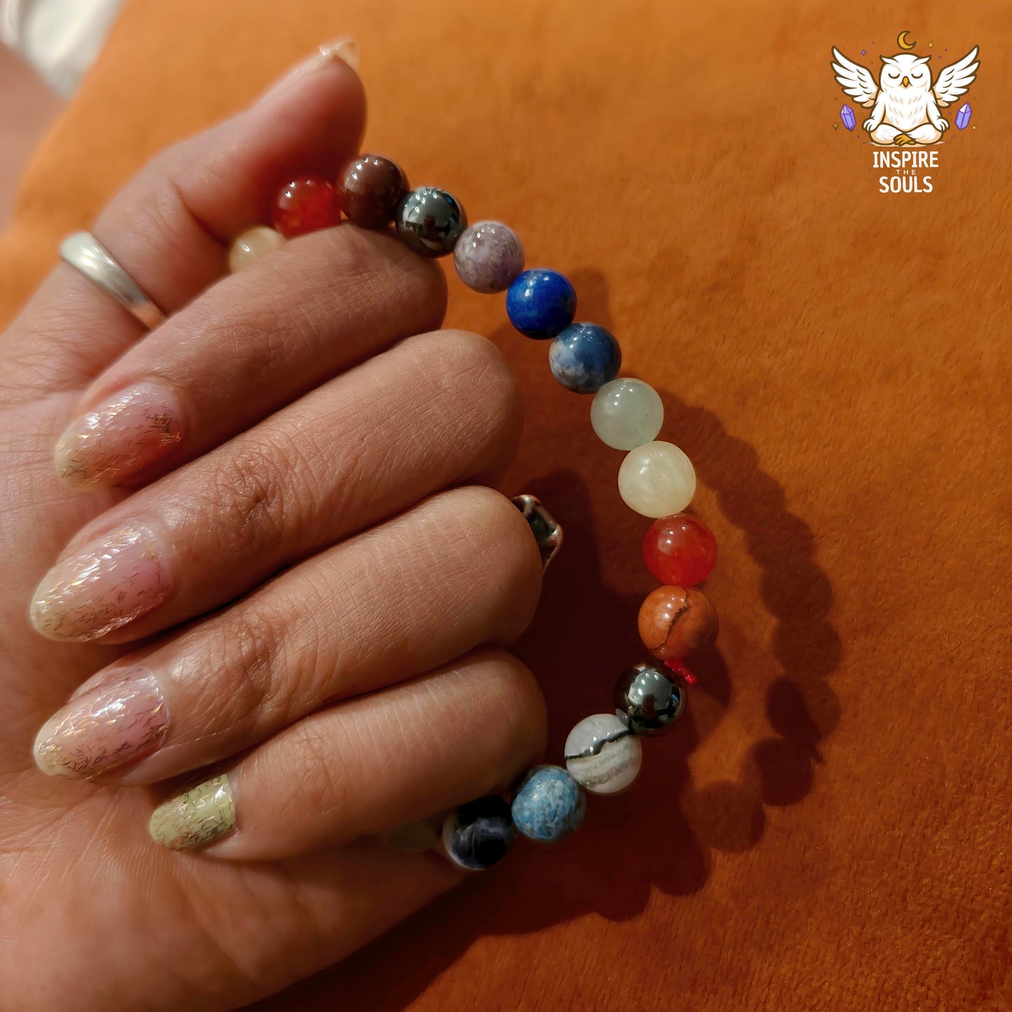 Hand holdinga 7 Chakra Bracelet by InspireTheSouls
